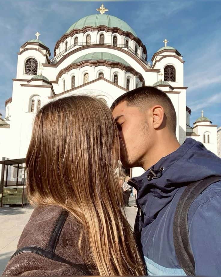 A couple embracing outside a cathedral