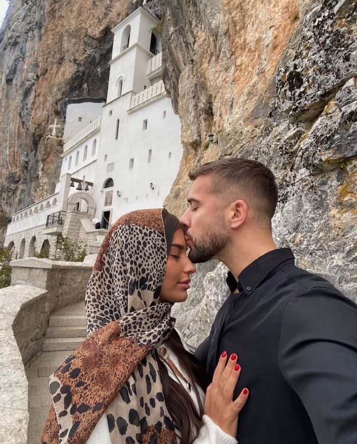 A couple visiting a cliffside monastery